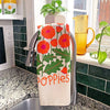 Kitchen towel with floral poppy design hanging over a faucet in a kitchen.