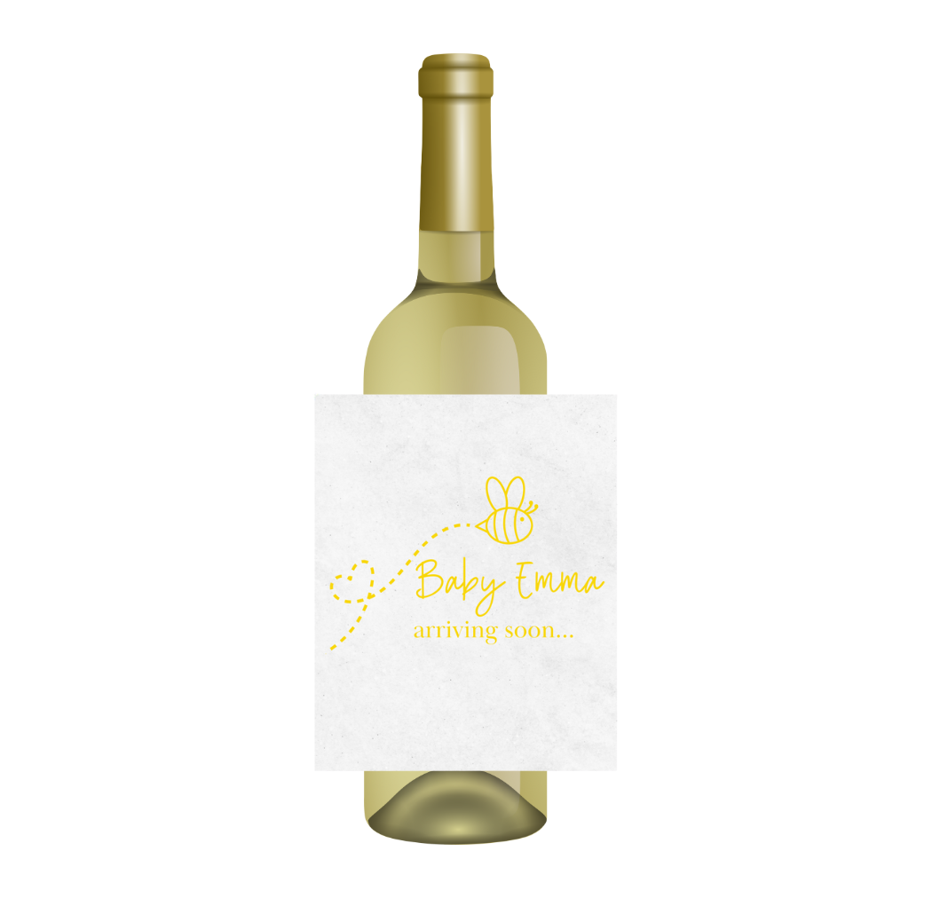 White wine bottle with a bee-themed baby shower label is shown against a white background. The label features a flying bee above text that reads "Baby Emma, arriving soon..."