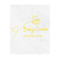 White wine label with yellow text 'Baby Emma arriving soon...' and a bee illustration is shown on a white background