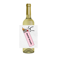 A white wine bottle with a custom paper label featuring a pink lighter illustration and the text 'BRIDGE BURNER'.