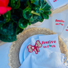 Napkin with 'festive as f*ck' text is featured on a decorative holiday table setting.