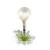 Clear lucite napkin weight in the theme of a golf ball on a tee in a tuft of grass against a white background