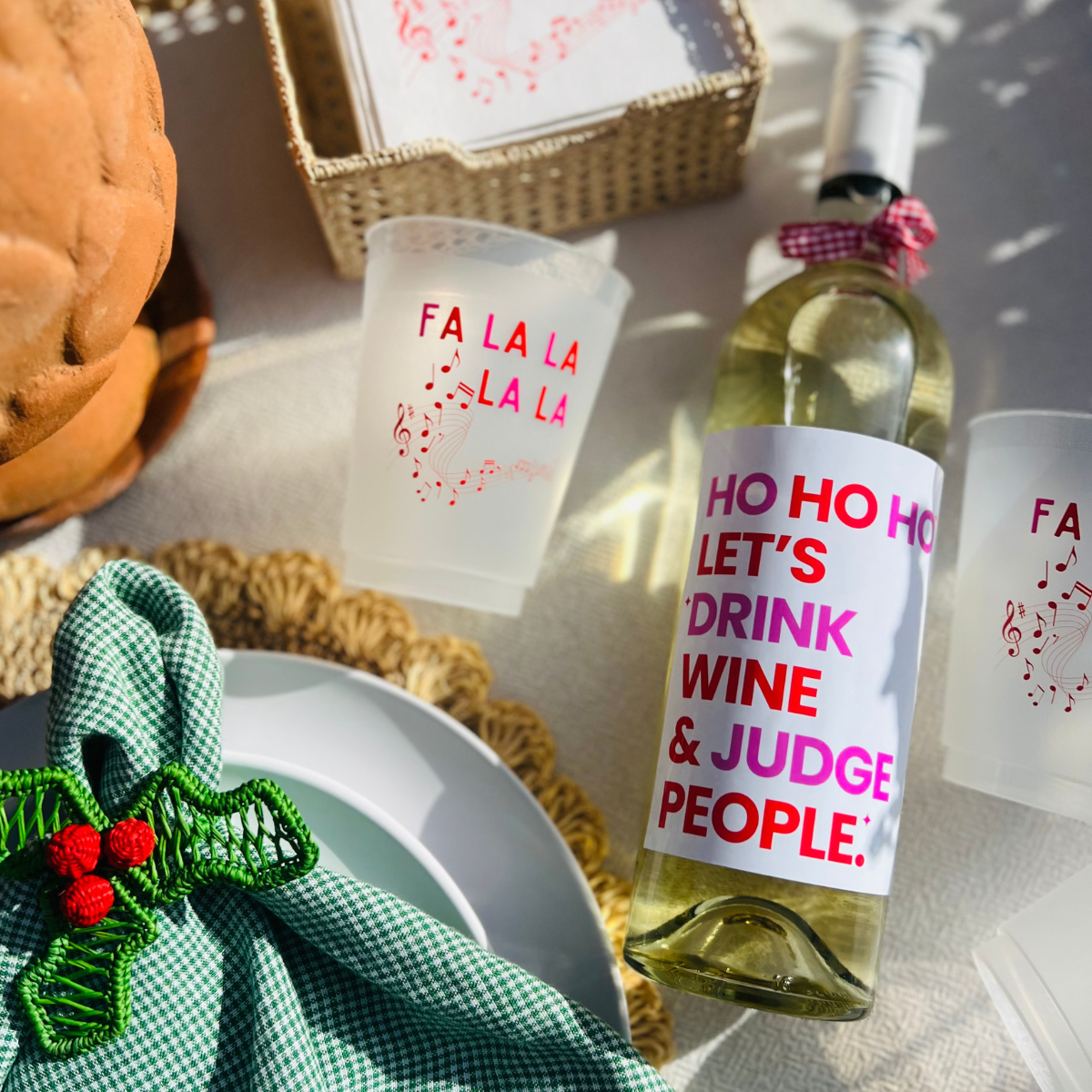 Close up of a fun holiday wine label that reads " Ho Ho Ho Let's Drink Wine & Judge People." Perfect for office Secret Santa exchanges, hostess gifts, or to add a little sass to your Christmas party décor. 