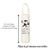An off-white canvas wine bag with a black graphic of a person pouring a drink and the text 'I LIKE BIG POURS + I CANNOT LIE'. White text on the left shows bag dimensions, and text at the bottom says it is made to fit standard wine bottles.