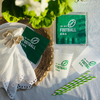 Green 'In My Football Era' products including napkins, a cup, and straws on a white surface with greenery for a Taylor Swift-inspired football watch party