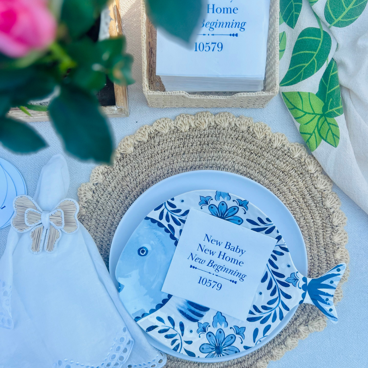 Decorative plate with blue floral design  is shown with a white cocktail napkin at its center. The text reads "New Baby New Home New Beginning" - a perfect closing or housewarming gift. 