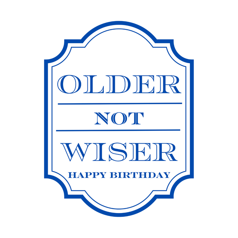 Close up of a white peel-and-stick wine label that features bold blue text that reads "Older Not Wiser - Happy Birthday."
