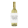 White wine bottle with a funny wine label for the holidays. The wine label features fun text that reads "Open this soon - there's a lot of family here." Perfect for gifting over the holidays, these hilarious, family-themed wine labels make great Secret Santa gifts, gag gifts, or fun party favors to enjoy with family.
