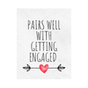 Wine label with  text 'PAIRS WELL WITH GETTING ENGAGED' and a heart and arrow design is shown against a white background. 