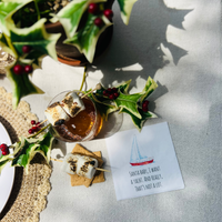 Santa Baby Napkin on table next to Smore's Old Fashioned Cocktail and mistletoe