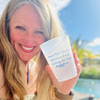 Woman holding a plastic cup with text that reads "Sorry for what I said when I was docking the boat" by a body of water