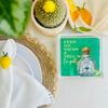 Tequila bottle acrylic napkin weight is shown on a green napkin with text 'Feed me tacos and tell me I'm pretty' on a table setting.