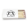 A novelty Halloween-inspired matchbox with black text that reads 'TIL DEATH do us PARTY' and a skeletal hand forming a heart shape. The open box contains light wood matches, and can be customized with up to 2 lines of text of the back.