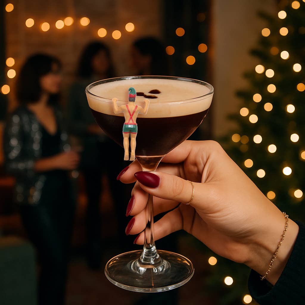 Hand holding a cocktail with a Christmas tree and blurred people in the background